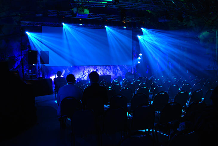 A performance with an audience, blue stage lights