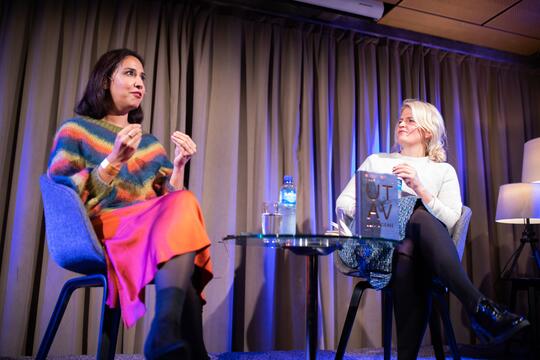 A writer talks about her book on-stage with a presenter at her side