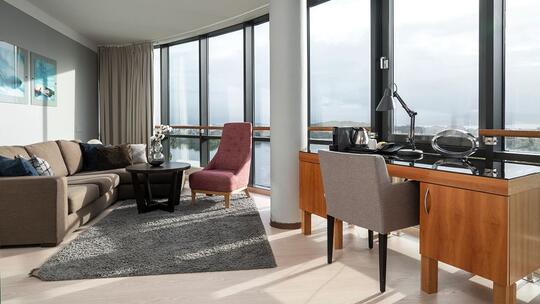 Suite med skrivebord og sofa og lenestol. Utsikt over Stavanger.