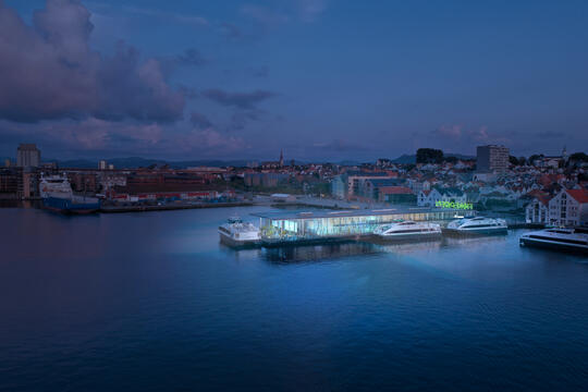 A large venue by the harbour in Stavanger by night - the building is lit up.