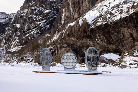 Art installation - 3 glass circles in front of mountains in the snow