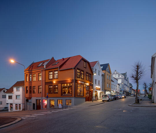 An orange painted wooden house in Pedersgata in Stavanger housing a restaurant